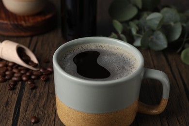 Photo of Mug of aromatic coffee on wooden table, closeup