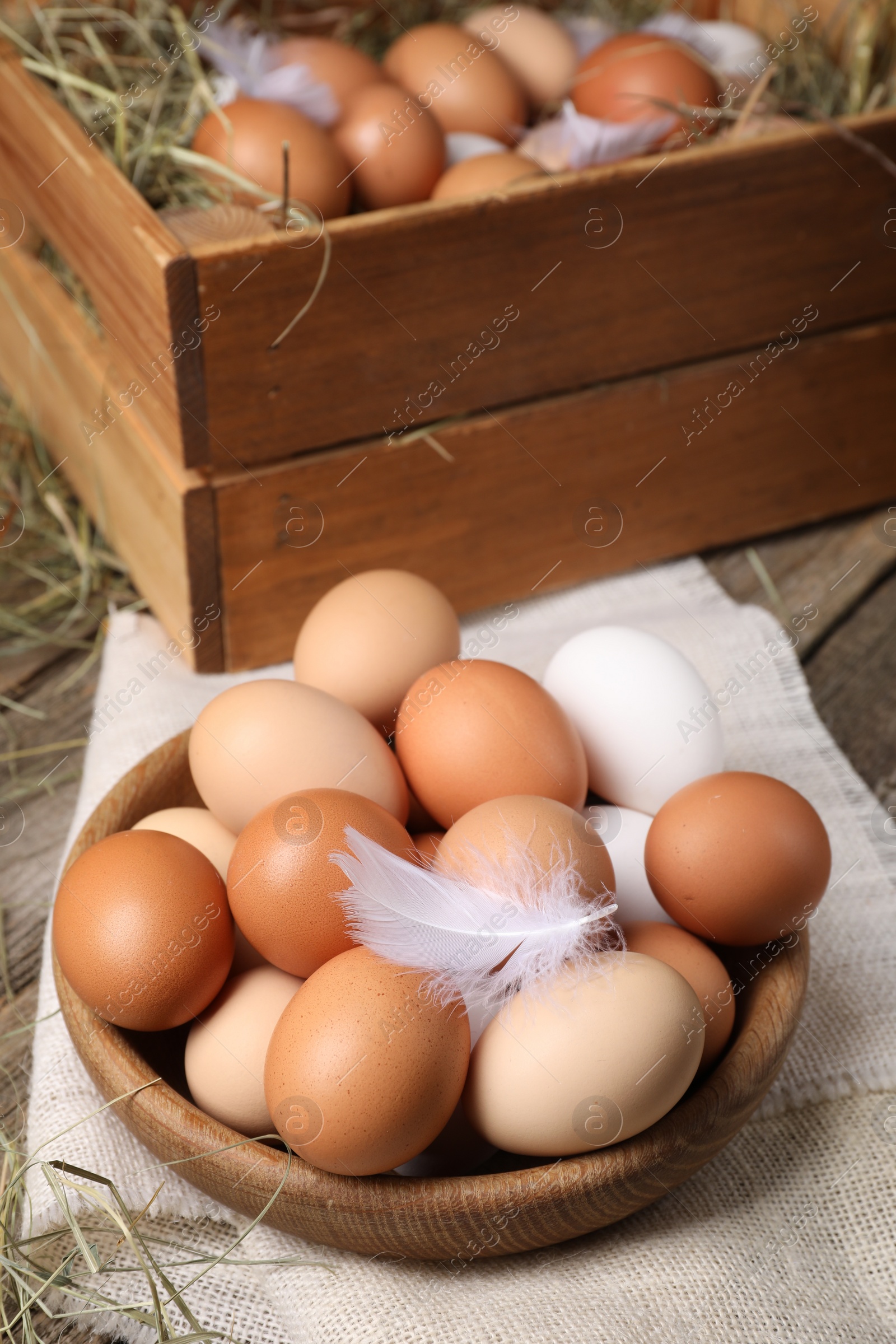 Photo of Fresh chicken eggs and dried hay on wooden table