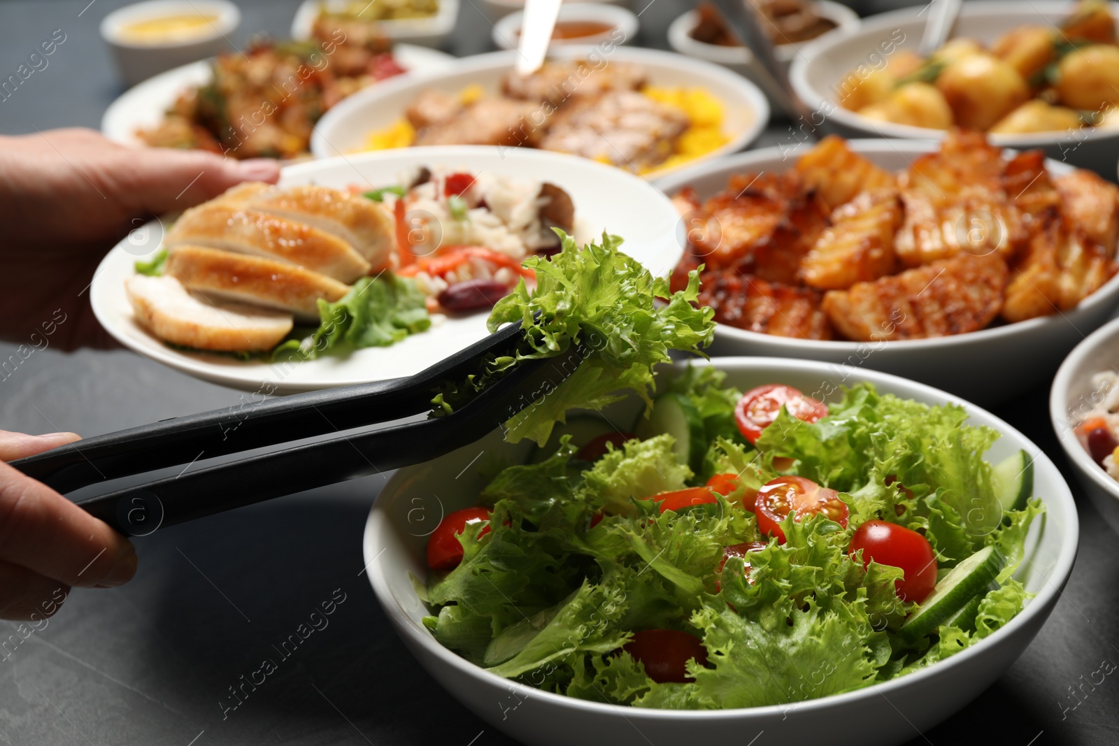 Photo of Woman taking food from buffet table, closeup