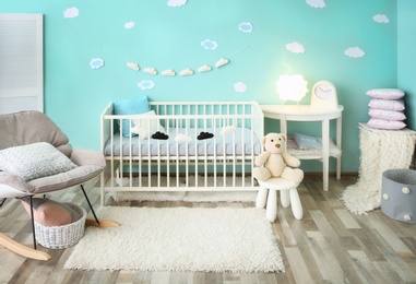 Photo of Modern baby room interior with crib and rocking chair