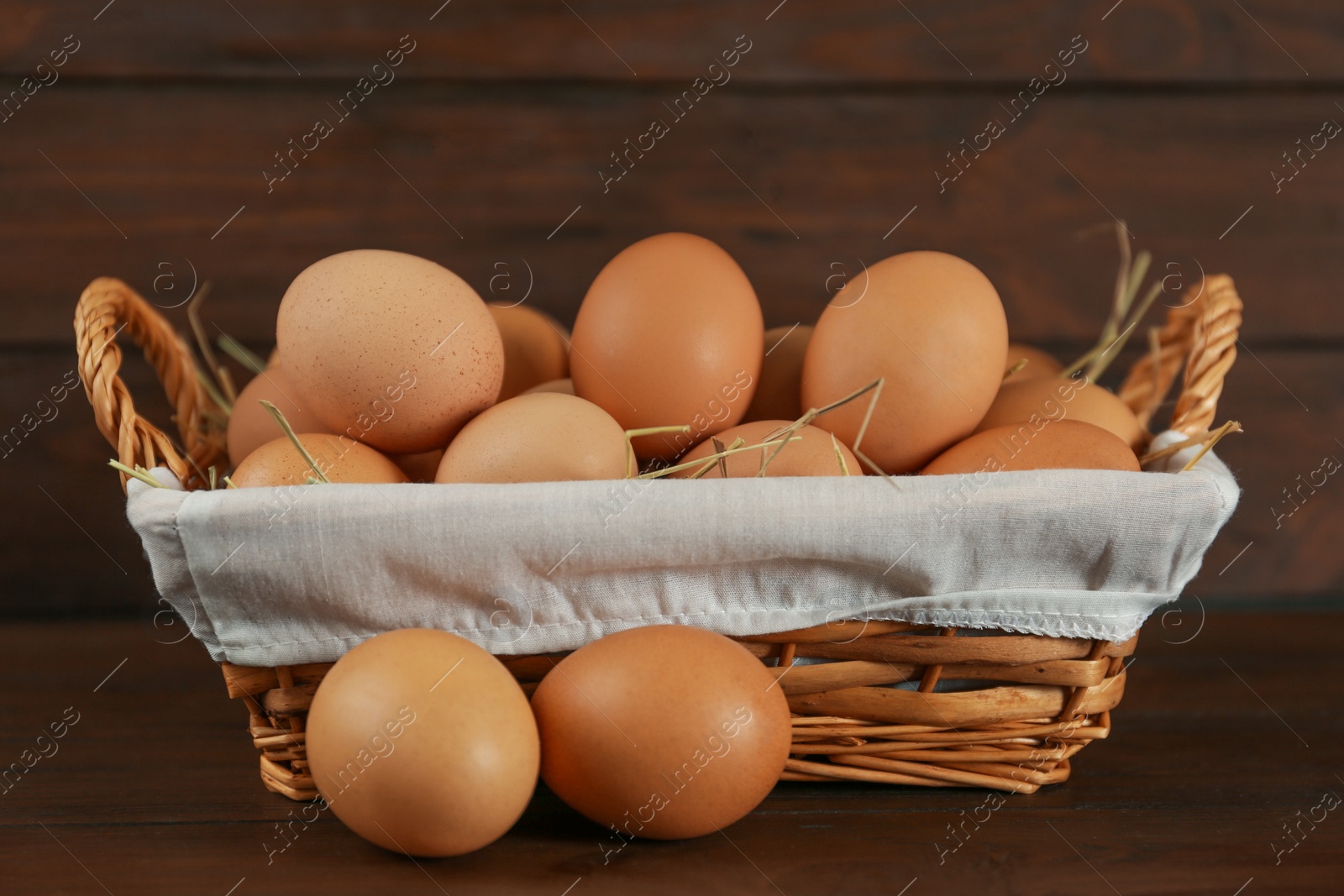 Photo of Raw brown chicken eggs on wooden table