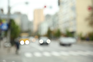 Photo of Blurred view of quiet city with buildings and cars on road