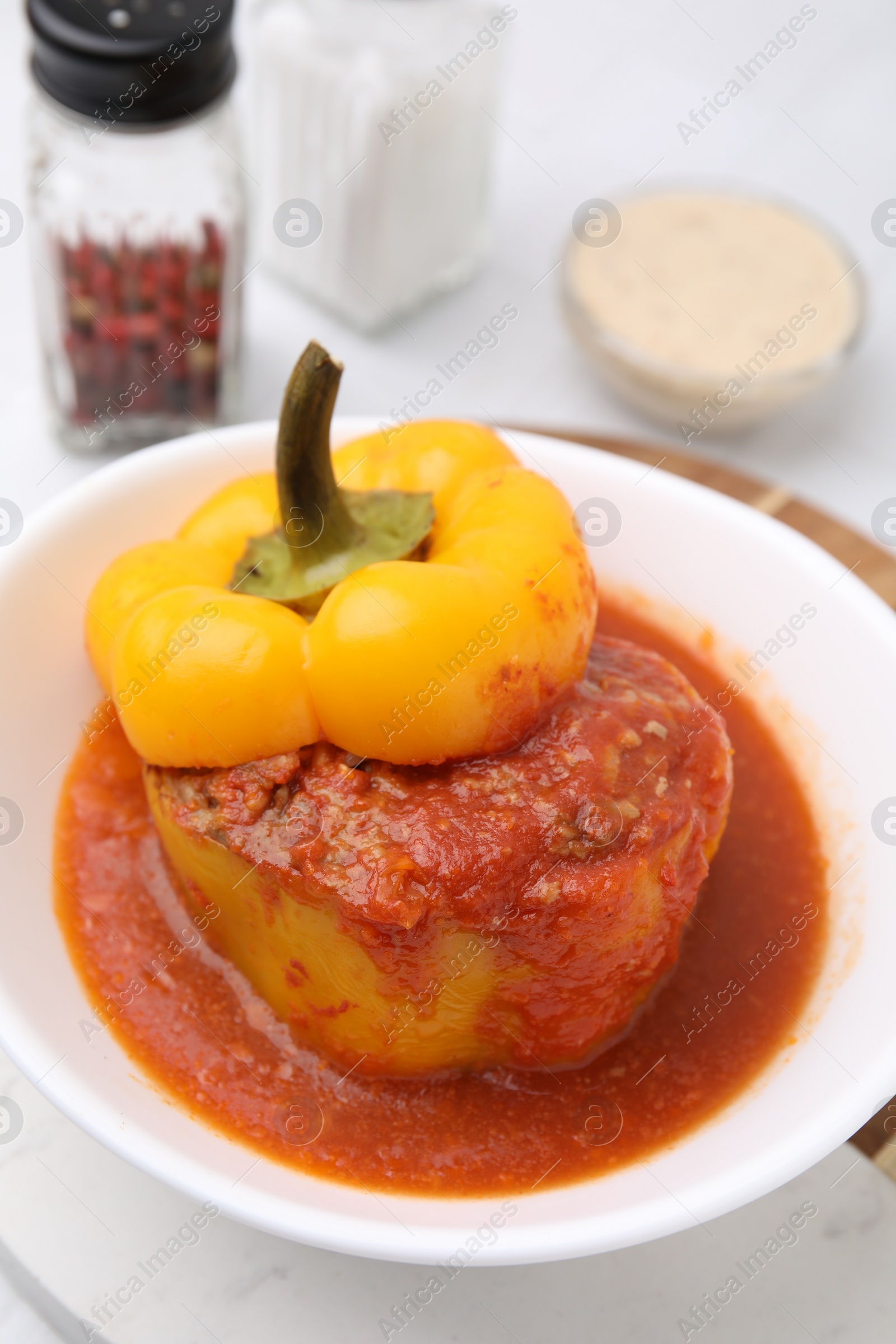 Photo of Delicious stuffed bell pepper served on white tiled table, closeup