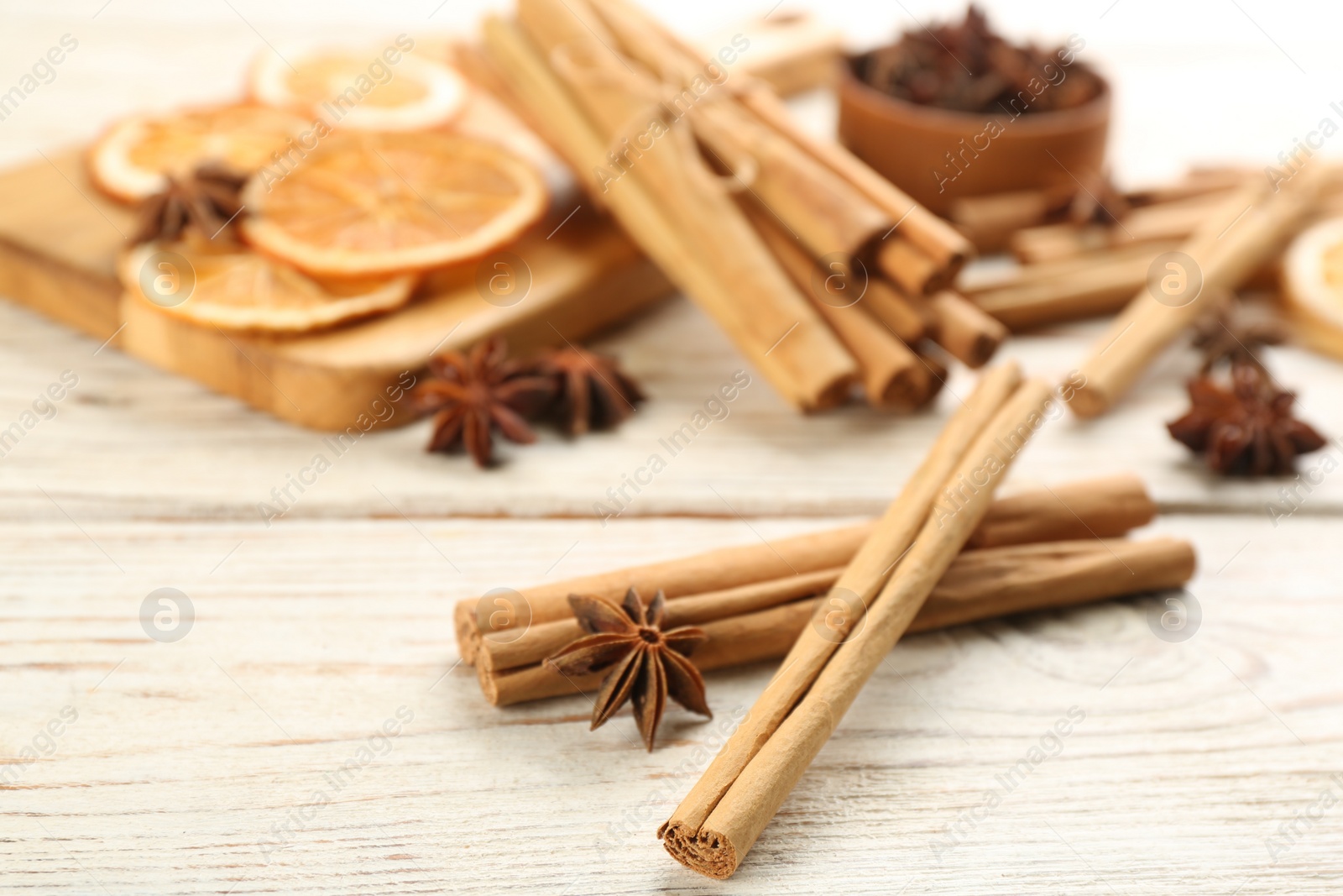 Photo of Aromatic cinnamon sticks and anise on white wooden table