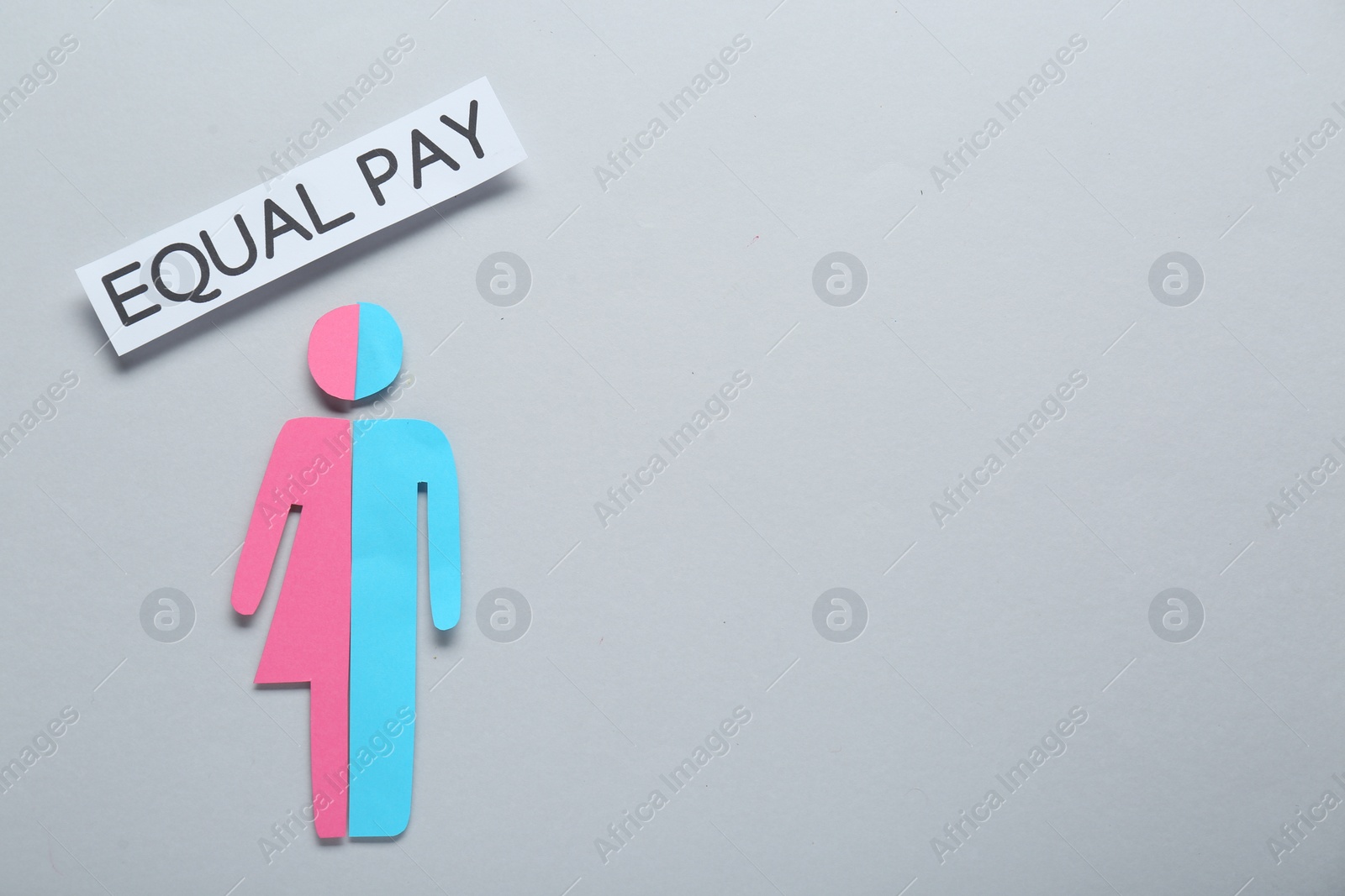 Photo of Equal pay concept. Human paper figure as male and female halves against light grey background, flat lay with space for text