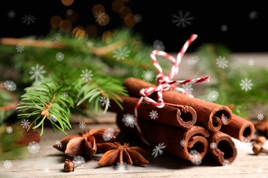 Image of Different spices and fir tree branches on white wooden table, closeup. Cinnamon, anise, cloves