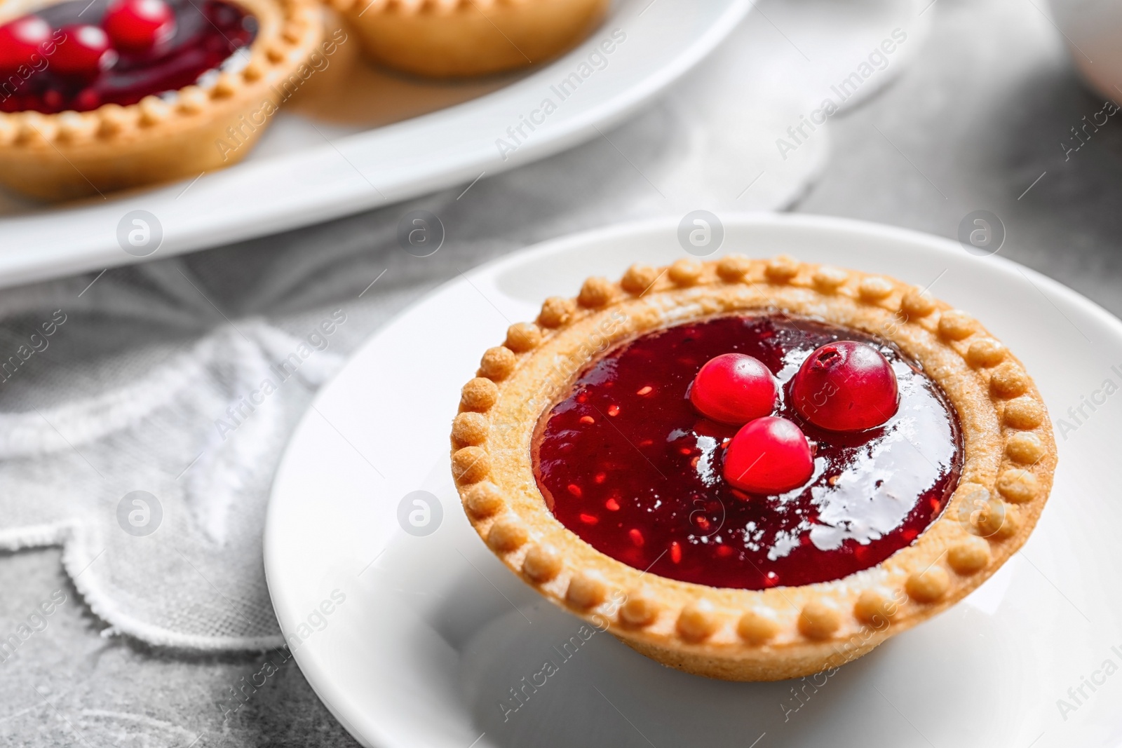 Photo of Tasty tartlet with jam on table, closeup