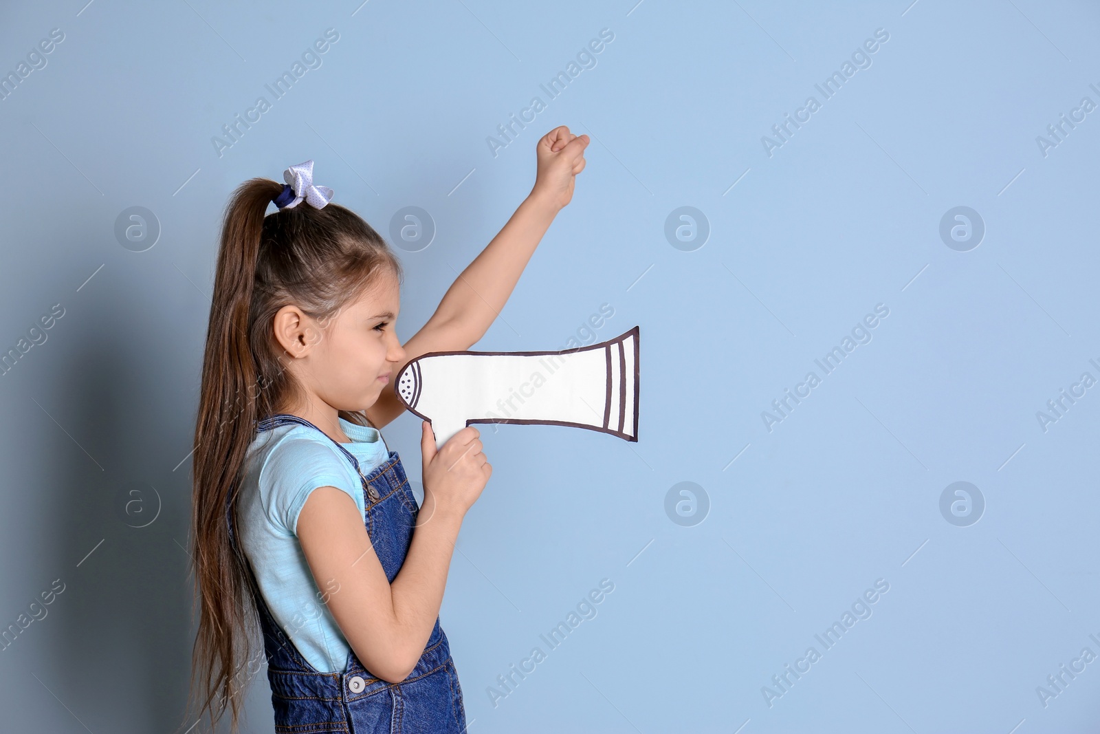 Photo of Cute little girl with paper megaphone against color background