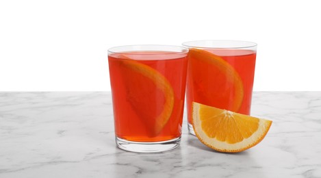 Photo of Aperol spritz cocktail and orange slices in glasses on marble table against white background