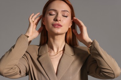 Photo of Beautiful young woman with elegant jewelry on gray background