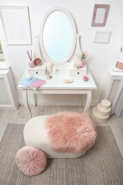 Dressing table with decor near white wall in room, above view