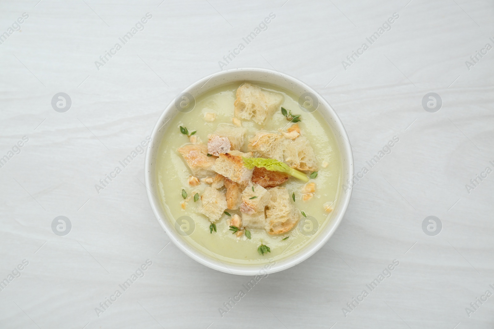 Photo of Delicious celery soup on white wooden table, top view