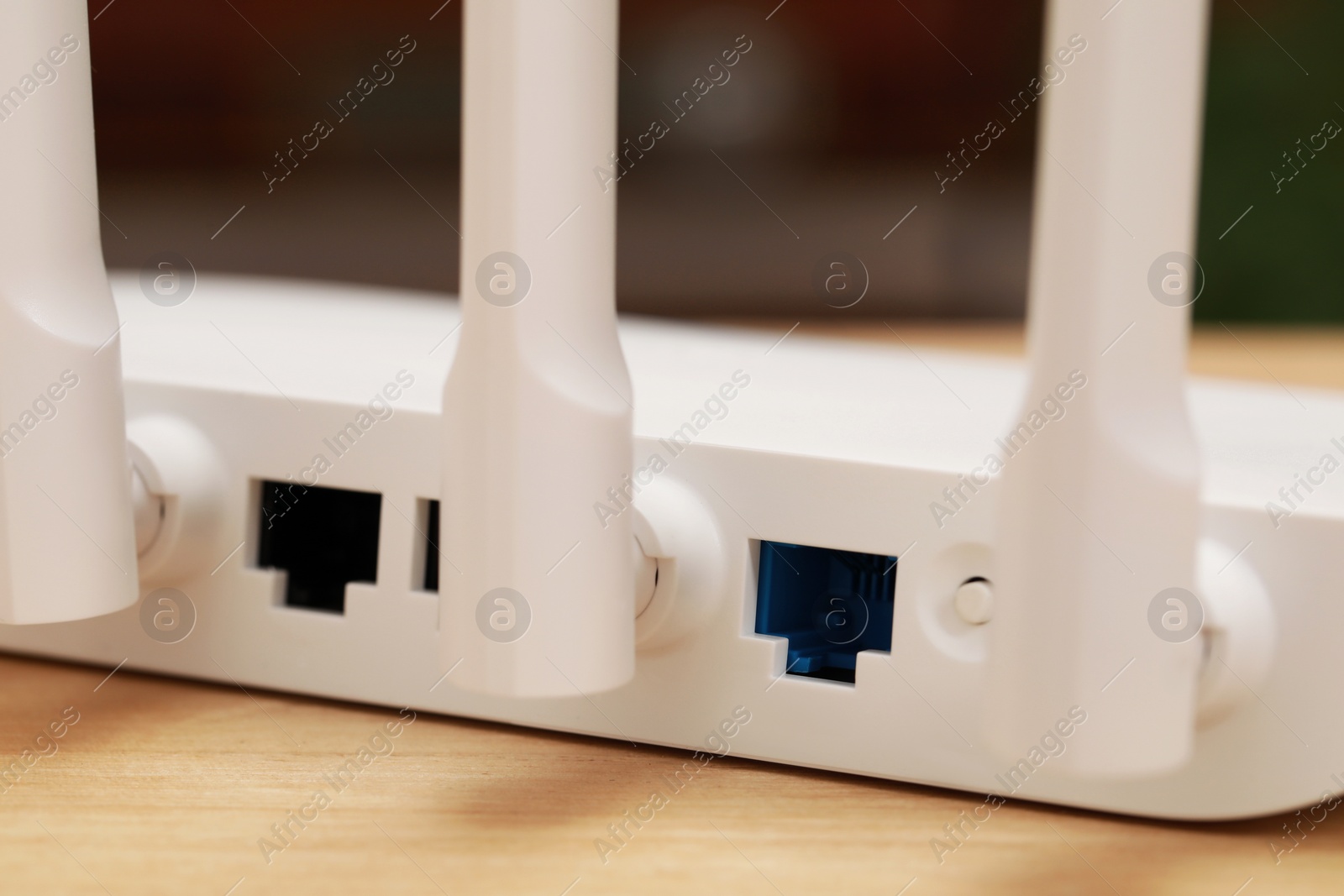 Photo of New white Wi-Fi router on wooden table, closeup