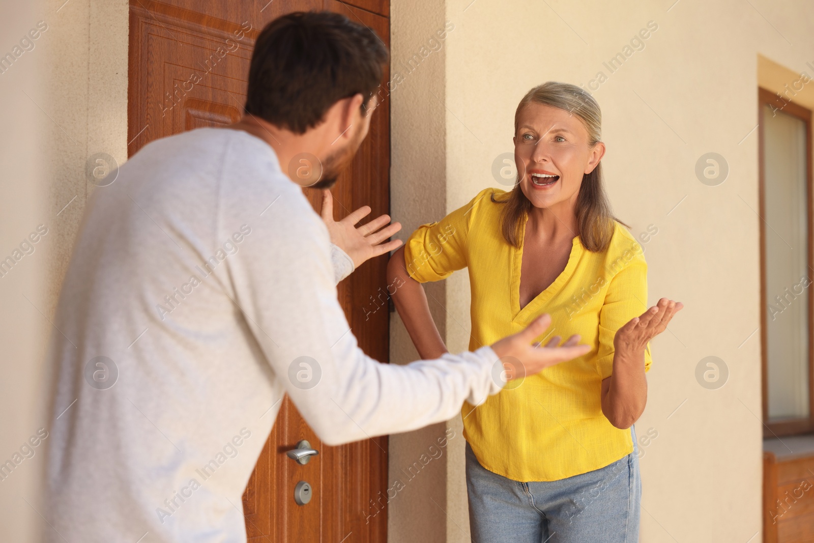 Photo of Emotional neighbours having argument near house outdoors