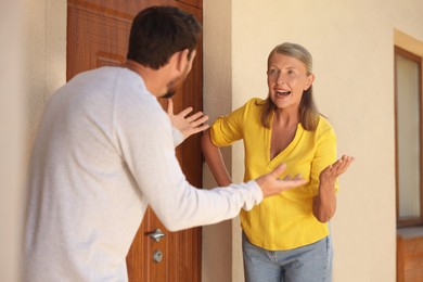 Photo of Emotional neighbours having argument near house outdoors