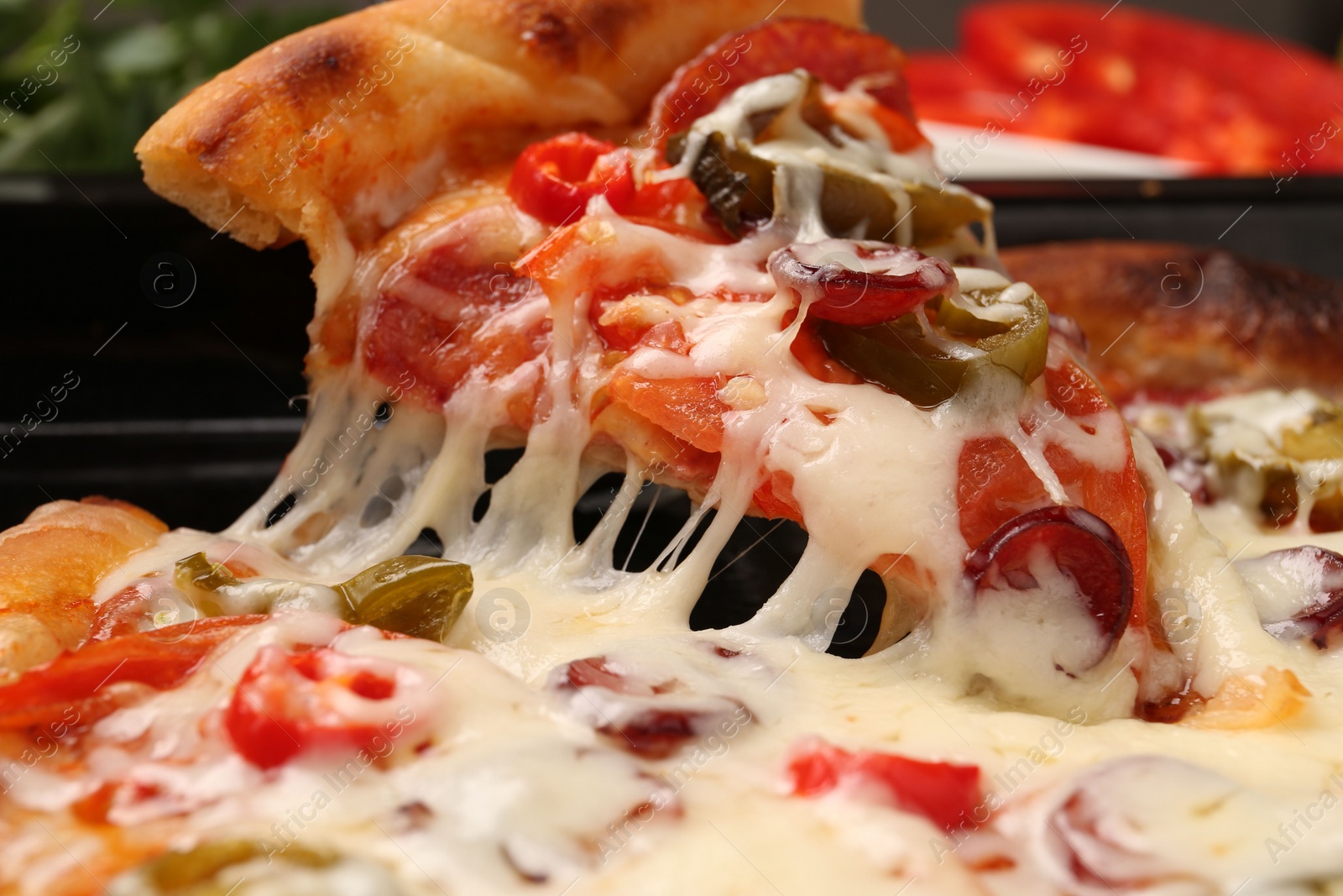 Photo of Taking piece of delicious pizza Diablo from baking tray, closeup