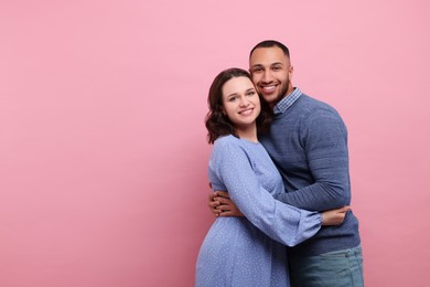 Photo of Lovely couple hugging on pink background, space for text. Valentine's day celebration