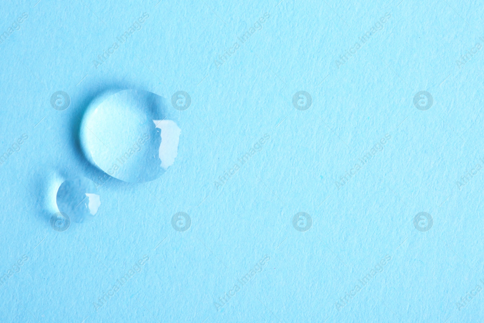 Photo of Water drops on color background, top view. Space for text