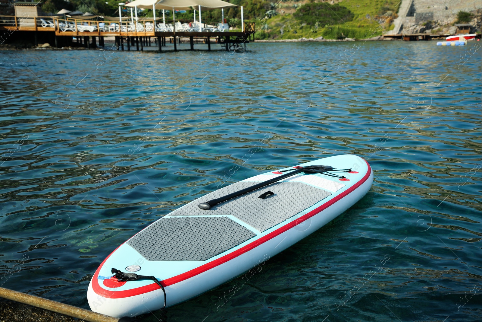 Photo of One SUP board with paddle near sea shore