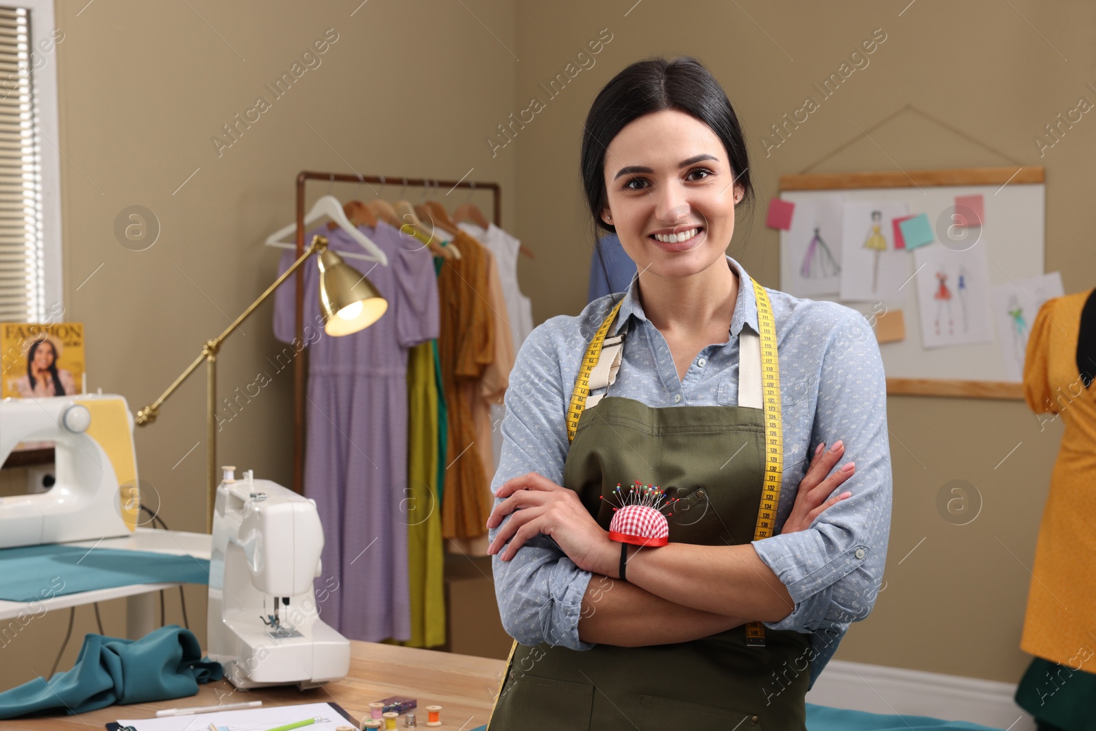 Photo of Professional dressmaker with measuring tape and pin cushion in workshop