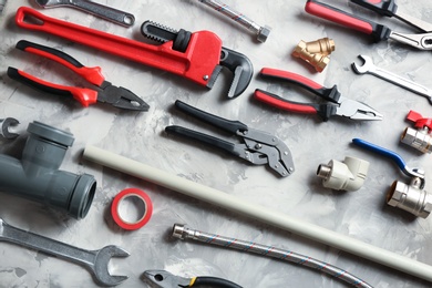 Photo of Flat lay composition with plumber's tools on grey background