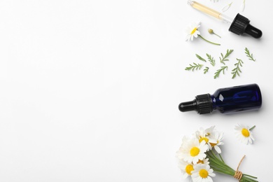 Photo of Composition with chamomile flowers and cosmetic bottle of essential oil on white background, top view