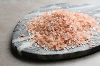 Photo of Pink himalayan salt on grey table, closeup