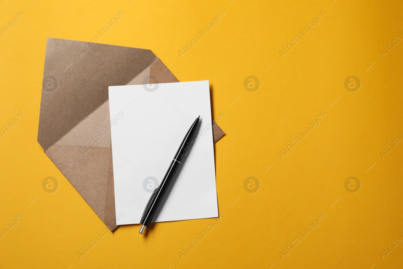 Photo of Blank sheet of paper, letter envelope and pen on orange background, top view. Space for text