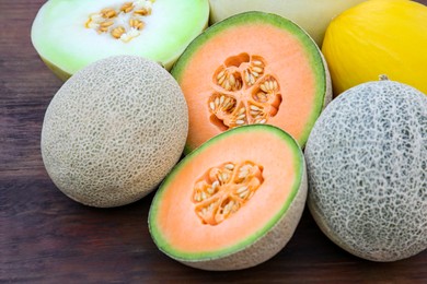 Different types of tasty ripe melons on wooden table