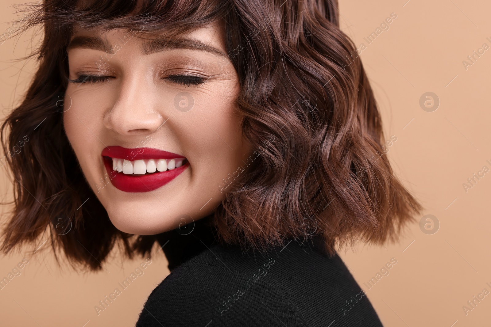 Photo of Beautiful young woman with wavy hairstyle on beige background