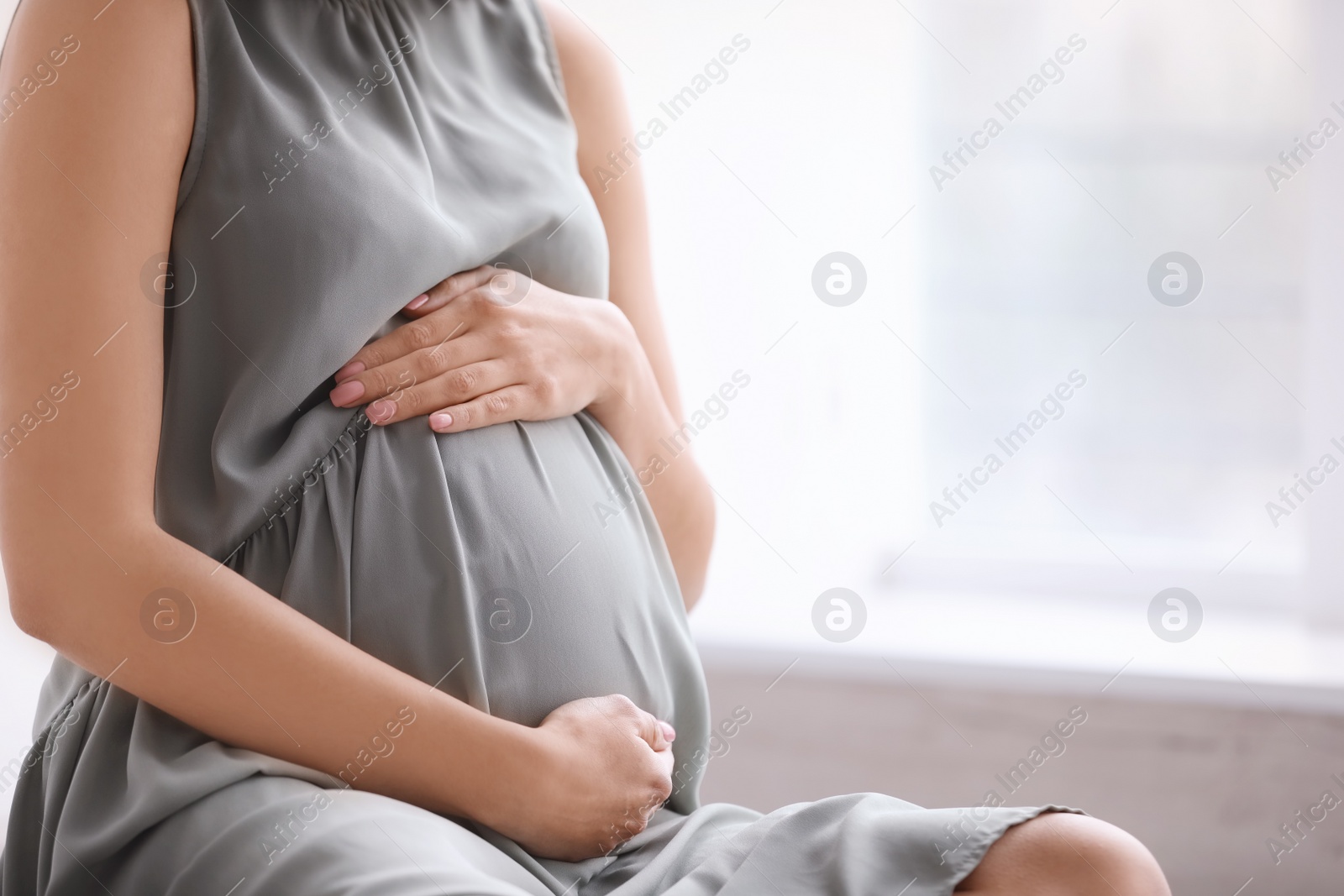 Photo of Young pregnant woman at home, closeup