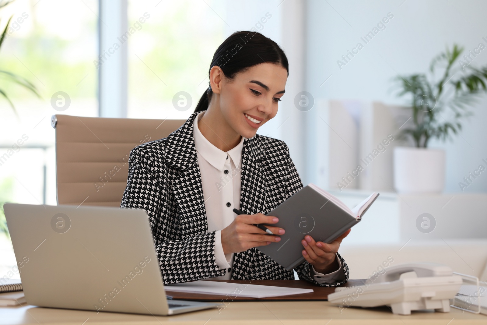 Photo of Secretary working at wooden table in office