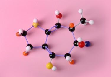 Photo of Structure of molecule on pink background, top view. Chemical model