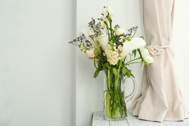 Vase with bouquet of beautiful flowers on table