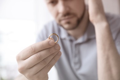 Image of Man with wedding ring, closeup. Cheating and breakup