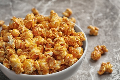 Delicious popcorn with caramel in bowl on table, closeup