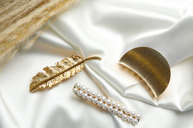 Photo of Beautiful different hair clips on white fabric, above view