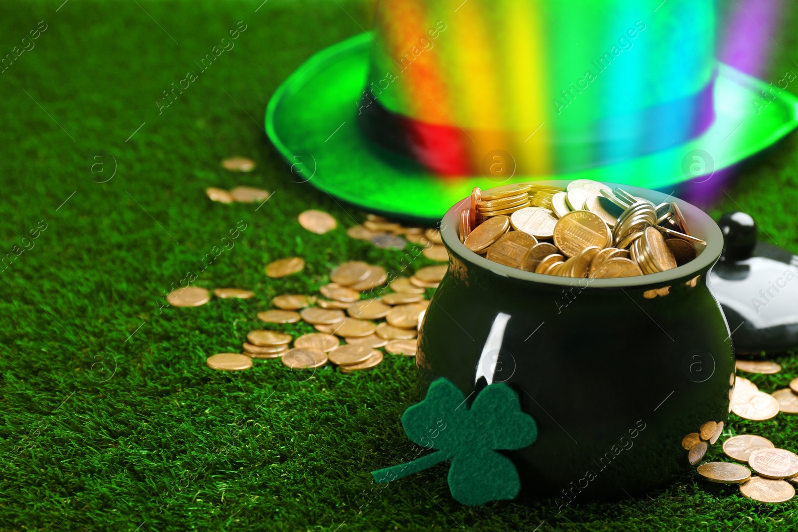 Image of Pot with gold coins, hat and clover on green grass, space for text. St. Patrick's Day celebration