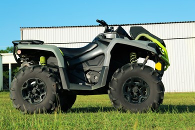 Photo of Modern quad bike in field near hangar on sunny day