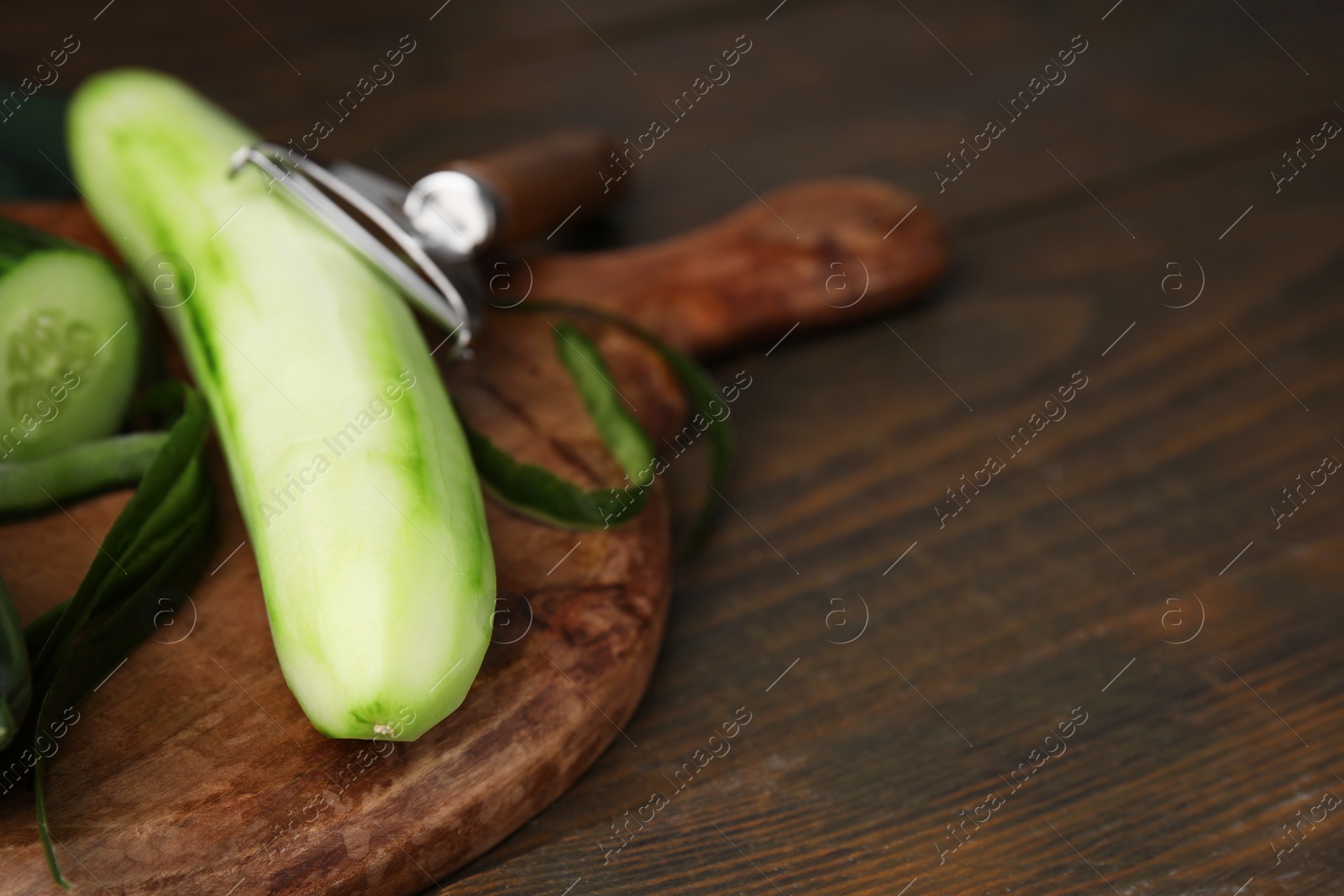 Photo of Fresh cucumbers on wooden table, closeup. Space for text