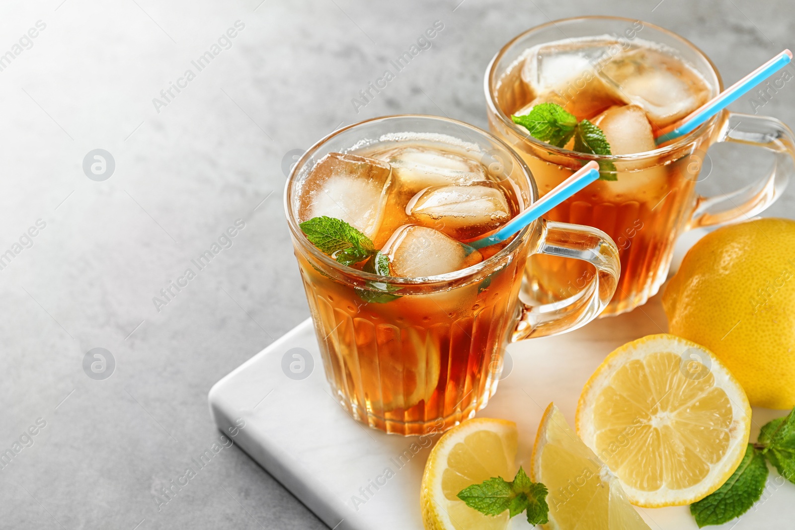 Photo of Cups of refreshing iced tea on light table