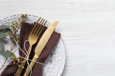 Photo of Stylish table setting with cutlery and eucalyptus leaves, top view. Space for text