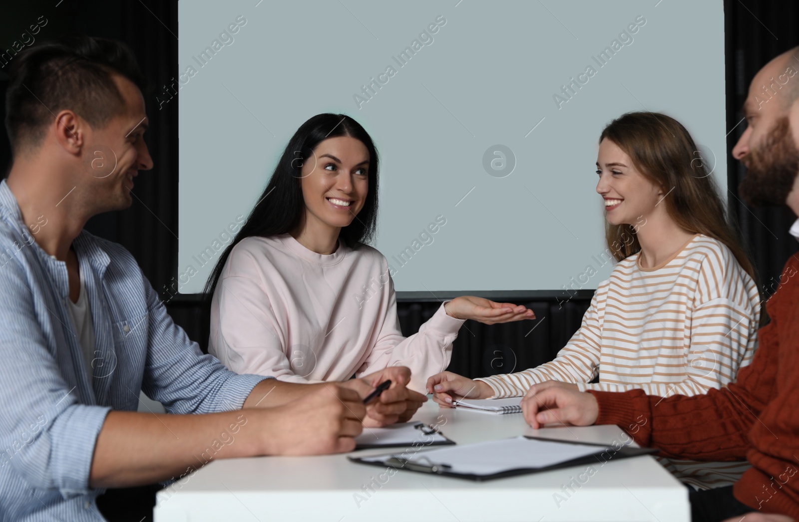 Photo of Business people having meeting in conference room with video projection screen