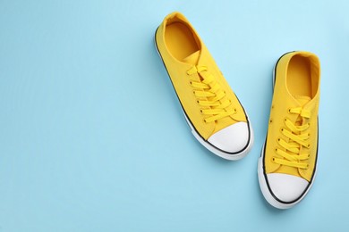 Photo of Pair of trendy sneakers on light blue background, flat lay. Space for text