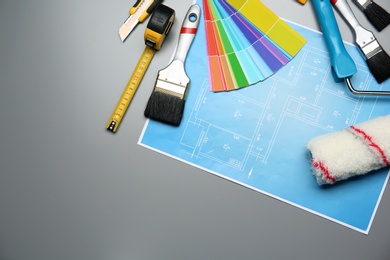 Photo of Set of decorator's tools and project drawing on grey background