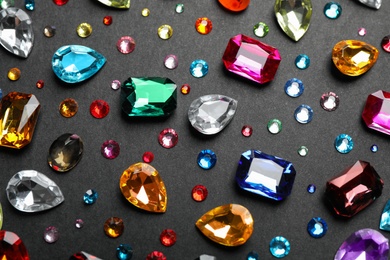 Photo of Different beautiful gemstones on black background, flat lay