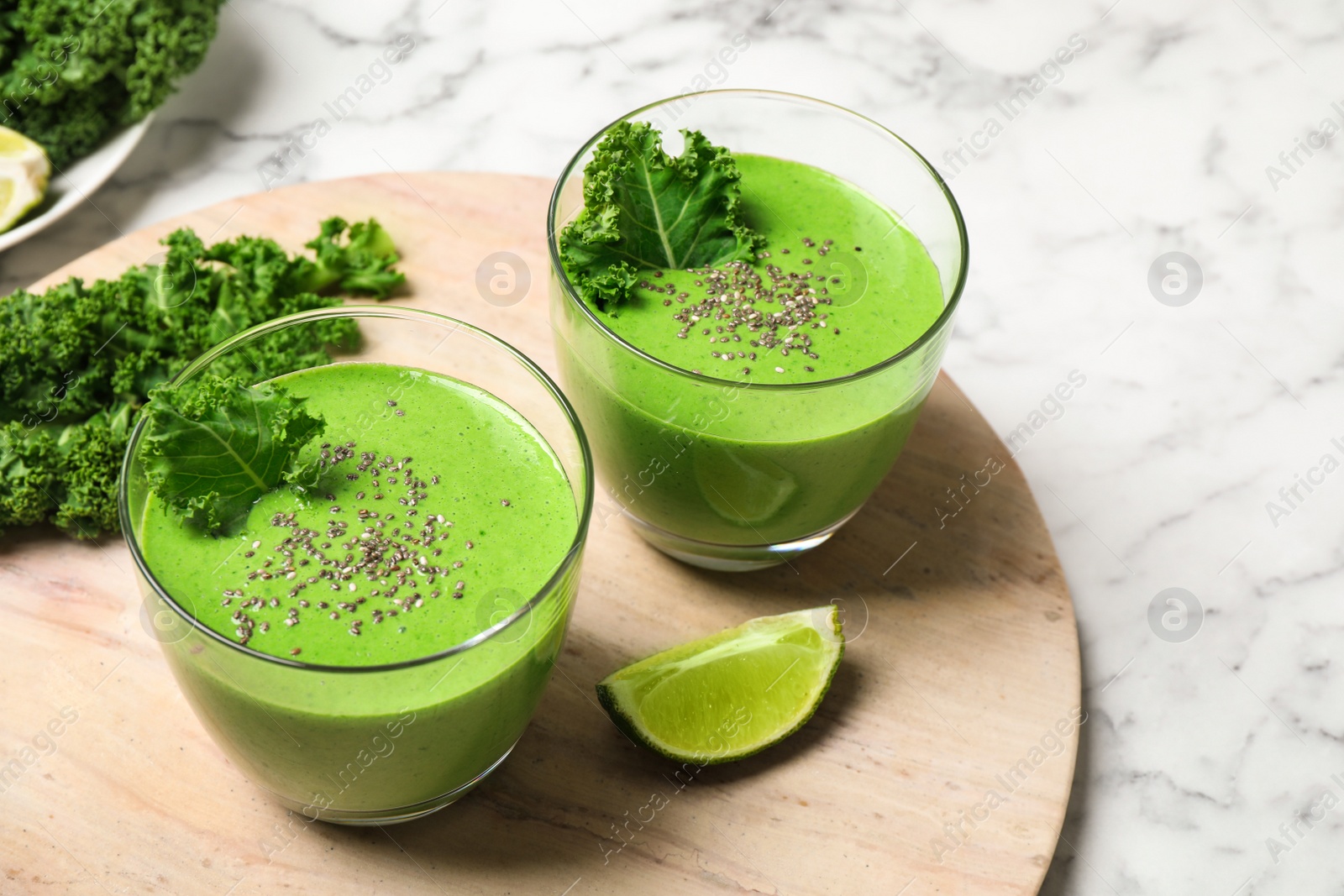 Photo of Tasty kale smoothie on marble table, closeup