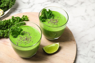 Photo of Tasty kale smoothie on marble table, closeup