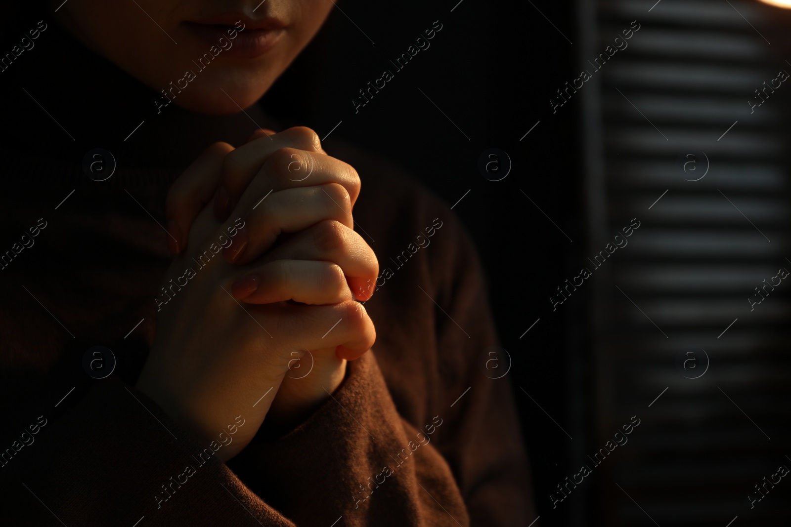 Photo of Woman praying indoors, closeup. Space for text