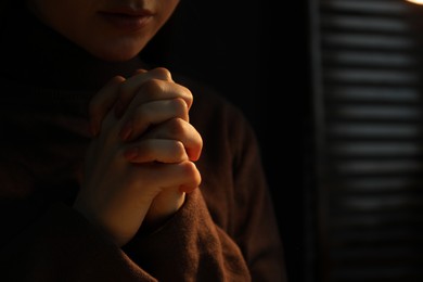 Photo of Woman praying indoors, closeup. Space for text